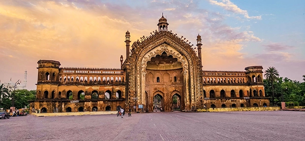 Sunset view of the historical Rumi Darwaza in Lucknow, India, with clear skies.